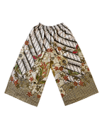 A pair of wide-leg cropped pants featuring a complex batik-style print with black and white stripes, floral motifs, and birds in earthy tones of brown, green, and red on a cream background.