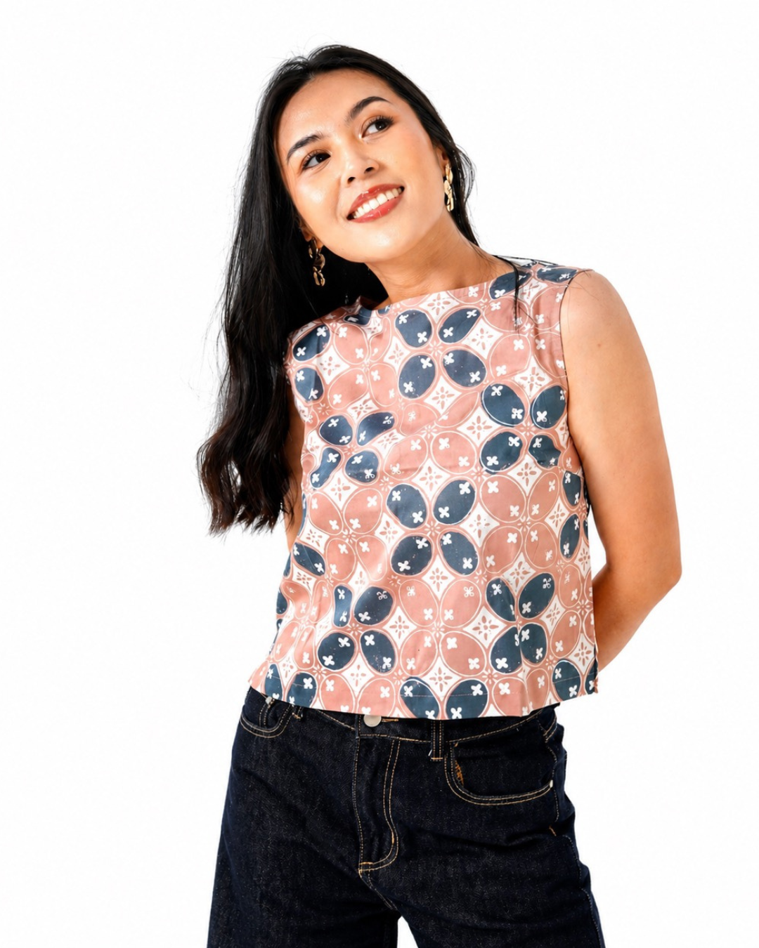 Woman wearing a sleeveless top with a pattern on a white background
