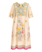 A short-sleeved midi dress with a cream base color, featuring a green, yellow, and pink floral and geometric pattern on the bodice and scattered floral motifs on the skirt. It has a pink hem and a matching patterned border.