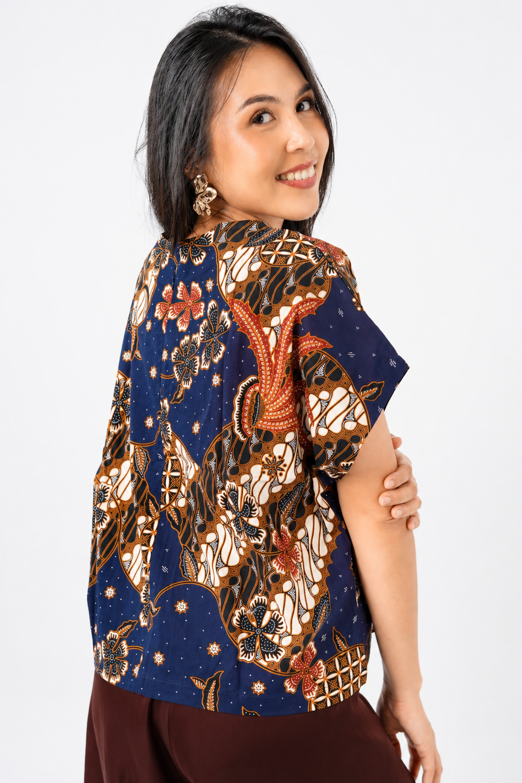 Woman wearing a traditional patterned blouse on a white background
