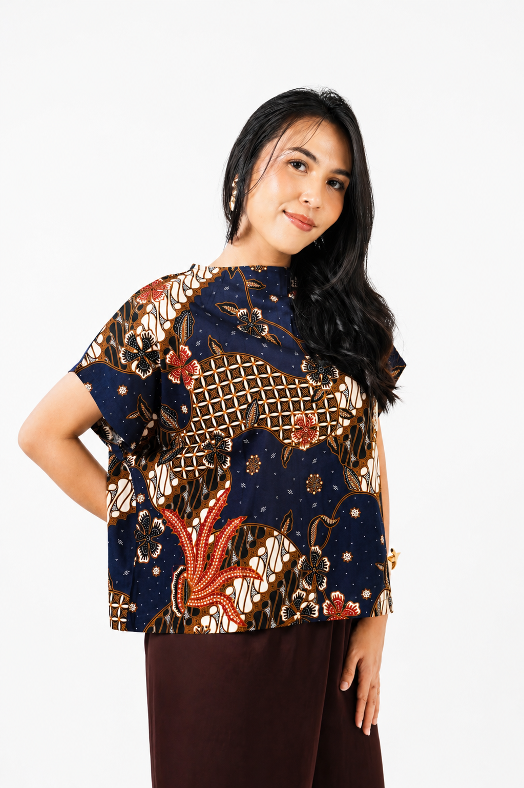 Woman wearing a patterned top on a white background