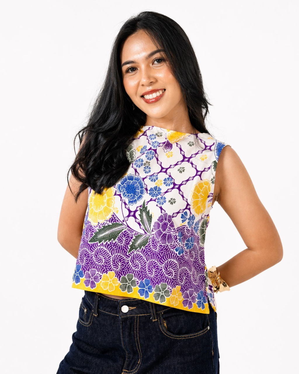 Woman wearing a colorful floral sleeveless top on a white background