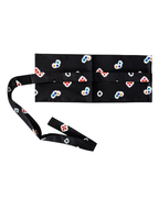 A black waist belt with a repeating pattern of small white, blue, and red floral motifs, laid flat on a white background with its strap extending to the left.