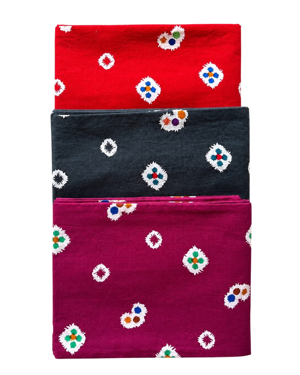 Three folded fabrics in red, black, and purple with floral patterns on a white background