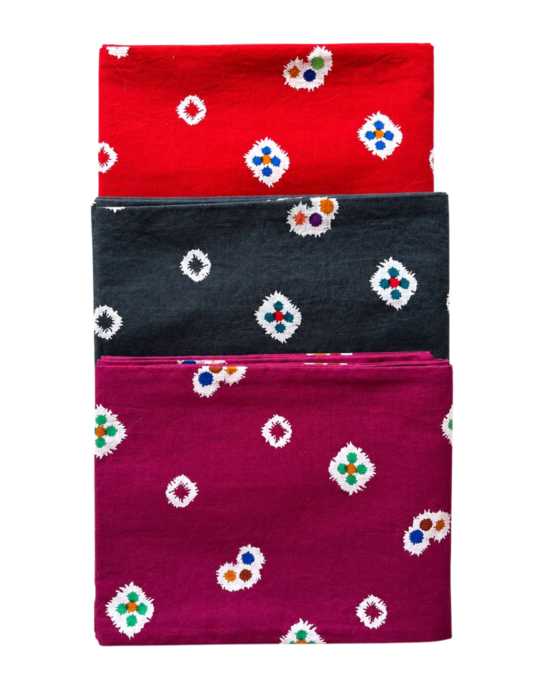 Three folded fabrics in red, black, and purple with floral patterns on a white background